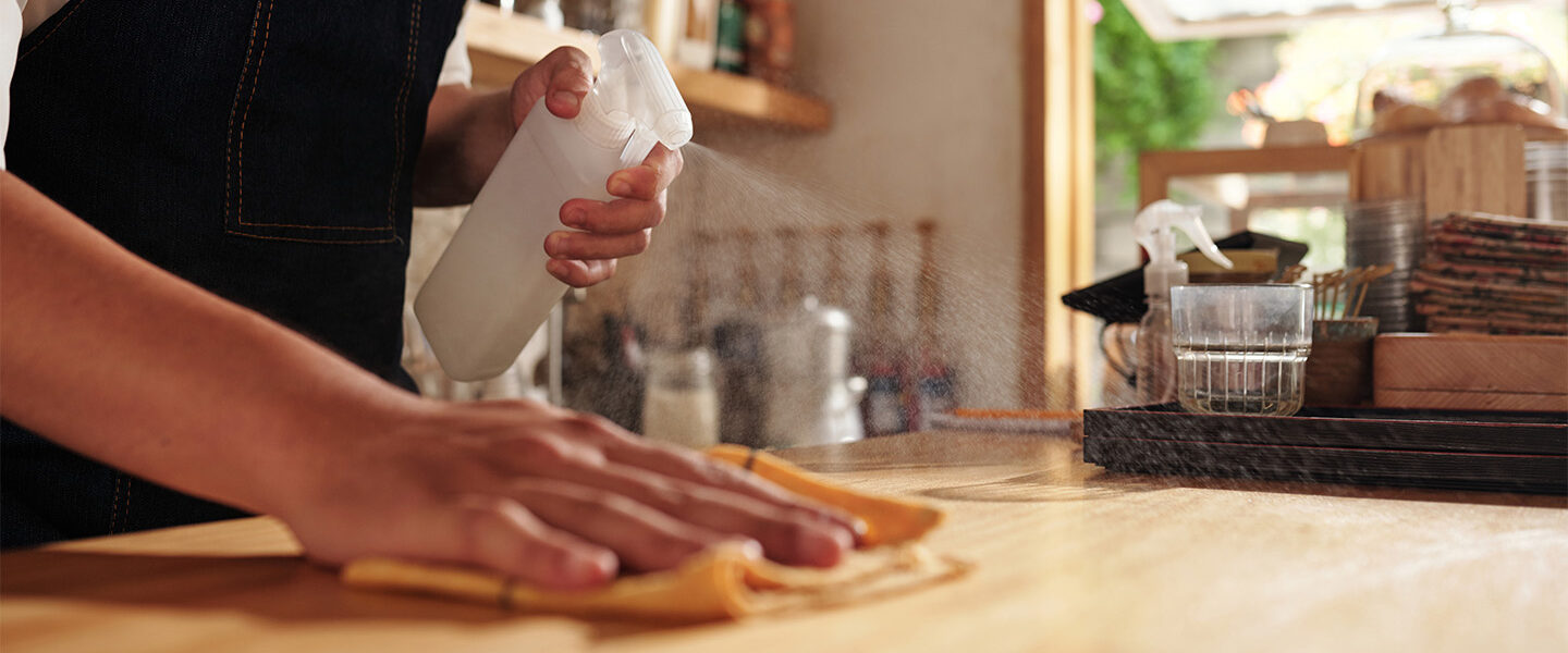 Wiping down kitchen surface representing Sagentia Regulatory's food contact materials compliance services