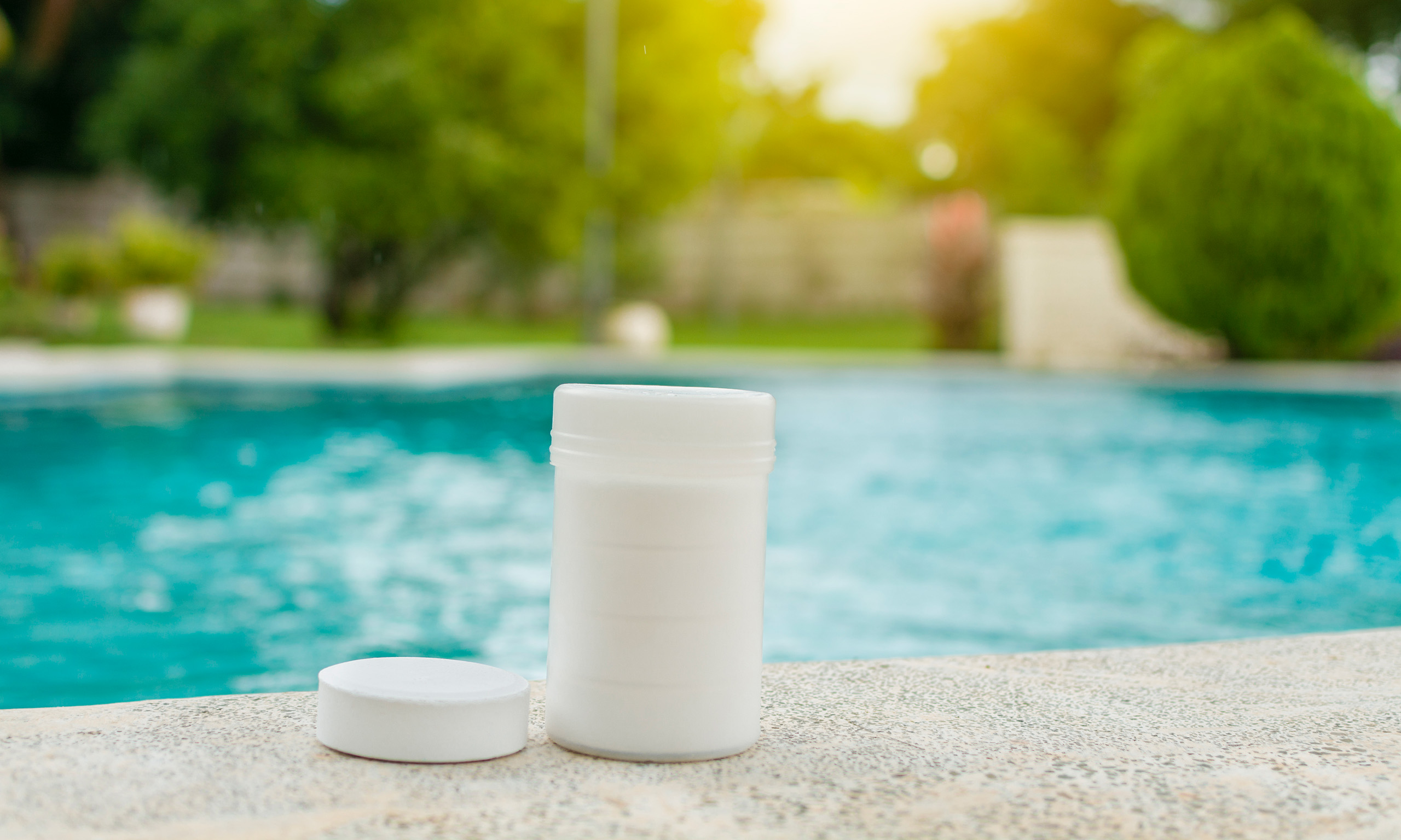 Chlorine tablets beside swimming pool representing Sagentia Regulatory's pesticide registration services in USA