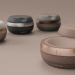Set of four round cosmetic compacts with copper bands on a neutral background, previewing a product line by Celleste (foreground close-up).