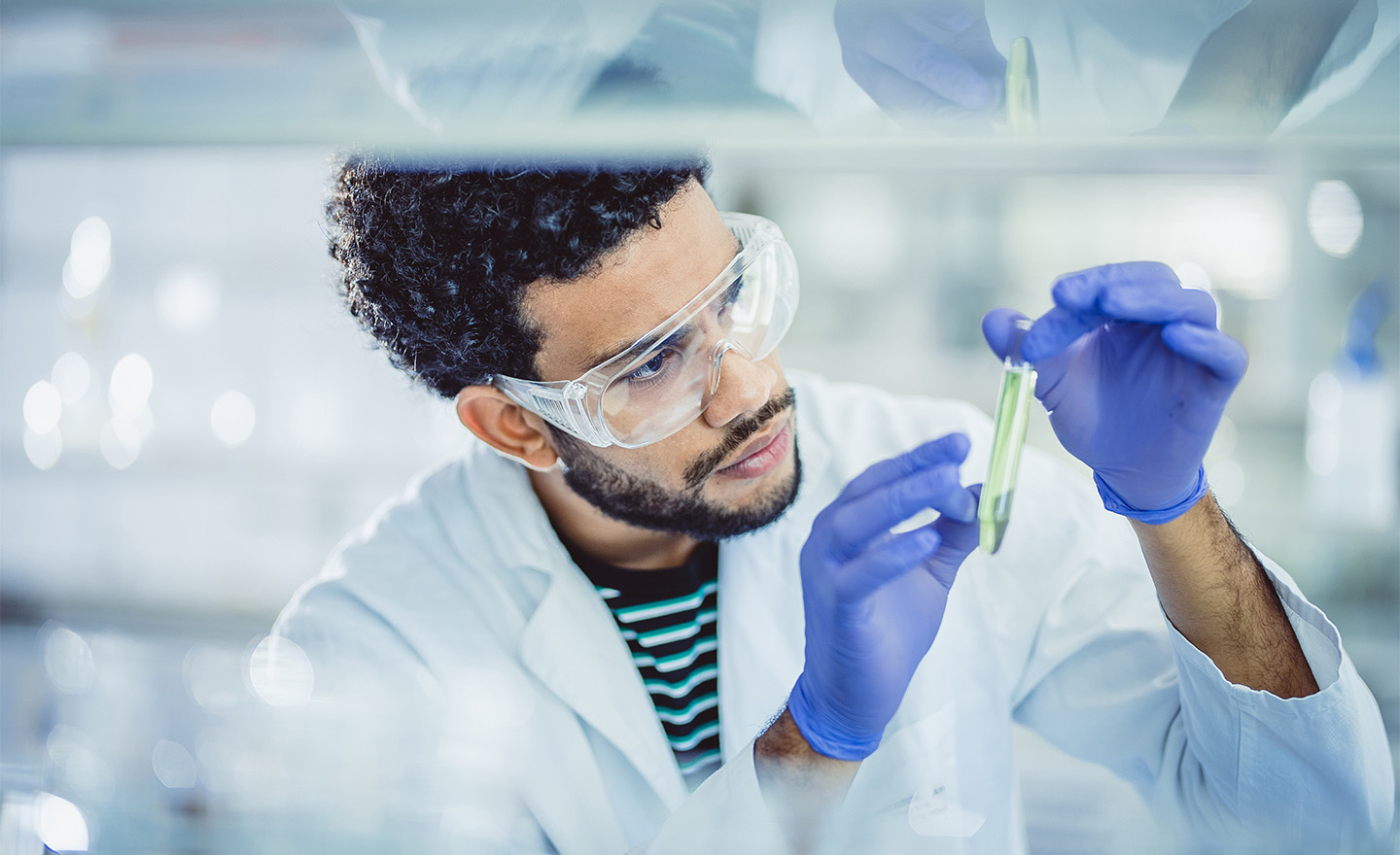 Scientist with test tubes in a lab, representing efficacy studies which are reviewed in a pesticide scoping document | Sagentia Regulatory