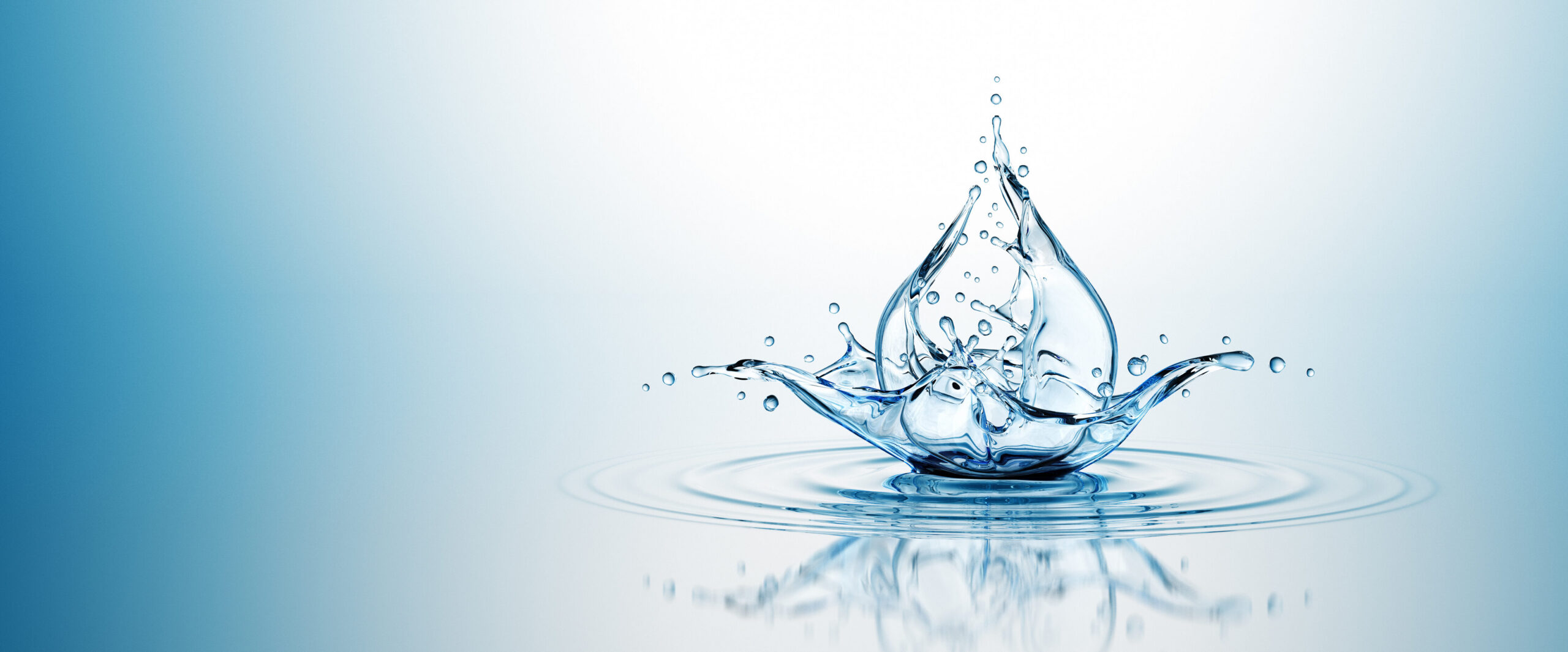 Water splashes upward, forming a crown-like shape with droplets over a reflective blue surface.