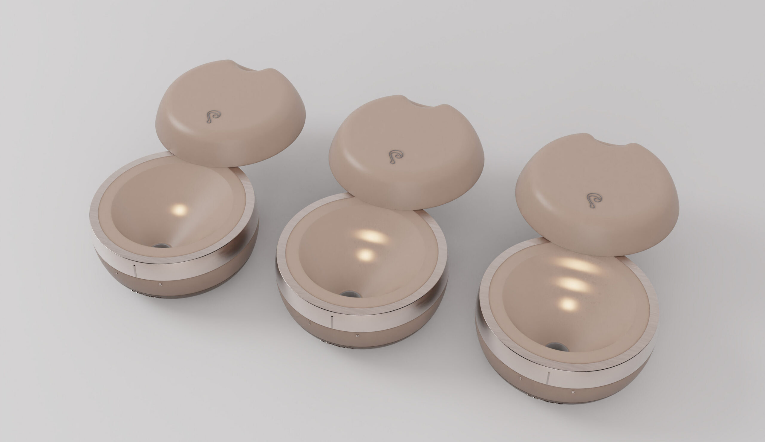 Three beige silicone prosthetic implants displayed with their open cases on a light background.